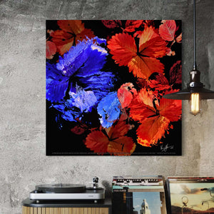 Colorful abstract painting of flowers on a gray wall above a record player.